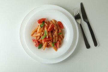 Plate with pasta with tomato sauce on white background