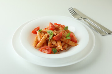 Plate with pasta with tomato sauce on white background