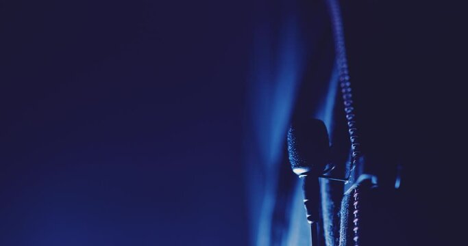 Close up of attaching a wired interview lavalier microphone to clothing