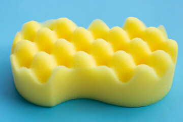 Yellow sponge for car washing on blue background.