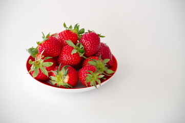 Strawberries on a plate against white background