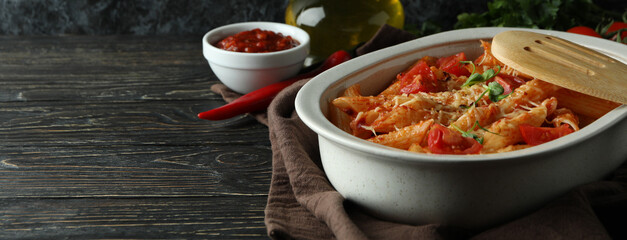 Tray with pasta with tomato sauce on wooden table, space for text