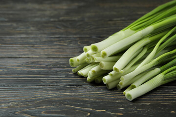 Fresh green onion on wooden table, space for text