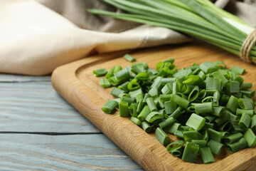 Fresh green onion on cutting board, on gray wooden table