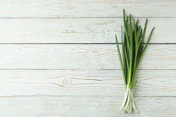 Fresh green onion on white wooden background
