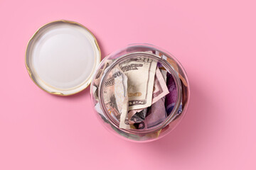 American dollars in glass money jar,top view, financial, saving. Money box, jar full of cash, save money concept, expense planning and control, free space for text.