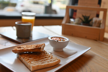 Toasted bread with tomato. Toast with crushed tomato. Delicious continental breakfast. Breakfast of toast with tomato, coffee and orange juice.