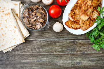 Shawarma ingredients. Thin pita bread, grilled meat, fresh vegetables, herbs, mushrooms for a tasty and healthy rolls. Copy space