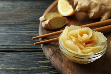 Tray with pickled ginger, chopsticks and ginger on wooden table