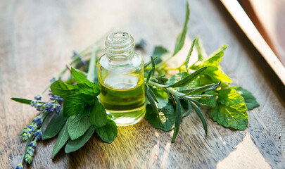 Green herbal essential oil bottle with plants and herbs