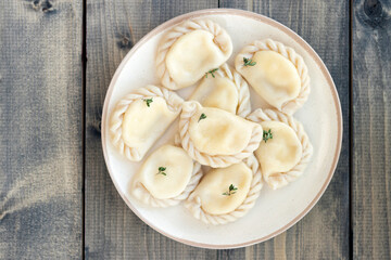 delicious, fresh Italian ravioli or dumplings on clay plate on a wooden table.