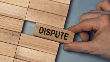 DISPUTE word concept. Close-up wooden piece blocks on the table