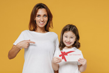 Happy woman in basic white t-shirt child baby girl 5-6 years old hold gift certificate coupon...