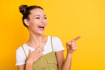 Photo of funny laughing lady hand chest direct finger look empty space wear green overall isolated yellow background