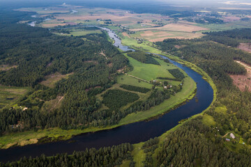 Aerial view of beautiful river bends and forests on a sunny summer day. 