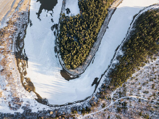 Aerial view of beautiful river bend and forests on a sunny winter day. 