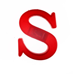 Plastic letter S of the English alphabet against white background, top view.