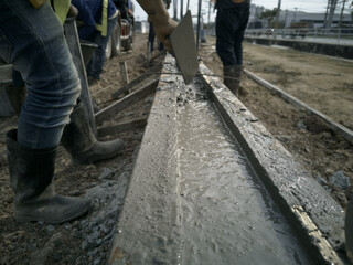 Plasterer is working on ground beams, Ground beams is constructed from concrete