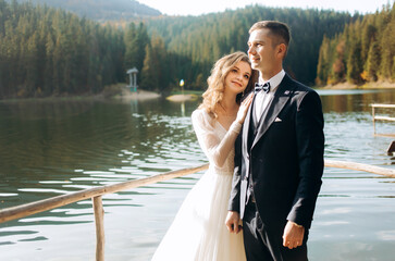Lovely couple near the lake in the mountains. A couple together against the backdrop of a mountain landscape.
