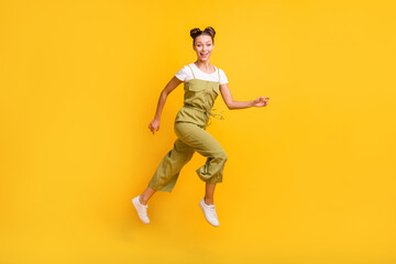 Fototapeta na wymiar Full length body size view of charming cheerful girl jumping running having fun isolated over bright yellow color background