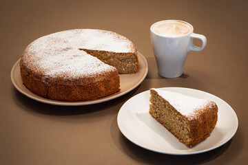 Piece of cake made of almonds and dry bread with cappuccino (Antica torta alle mandorle e pane)