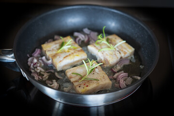 fresh cooking at home - roasted trout fillet in olive oil with red onions and rosemary