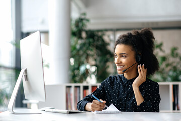 African American friendly young woman with headset, call center worker, consultant, business...