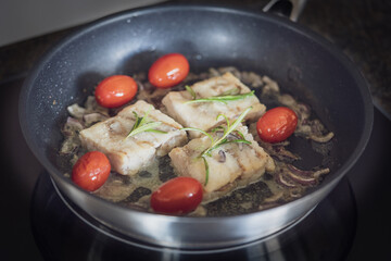 ready to eat - roasted trout fillet with cherry tomatoes, onions, rosemary in olive oil