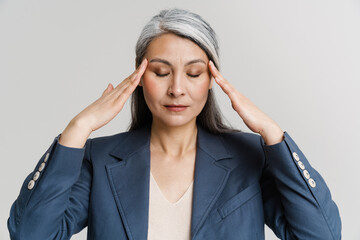 Asian mature woman with headache rubbing her temples