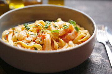 Tagliatelle with prawns in tomato and cream sauce.
Culinary photography. Suggestion to serve the dish.
