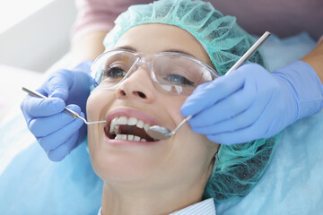 Dentist examining oral cavity of woman patient