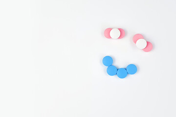 Smiling face sign made of vitamins. Vitamins and supplements isolated on white background. Concept for a healthy dietary supplementation. Close up. Copy space.