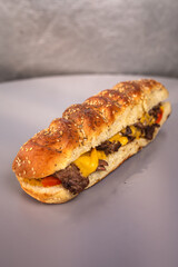 sandwich in a loaf with sesame seeds on a gray background.