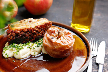 Pork ribs baked with apples served on a plate.
Culinary photography. Suggestion to serve the dish.
