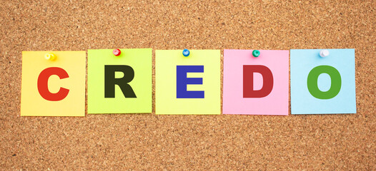 Word CREDO. Color notes with letters pinned on a board.