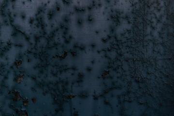 黒い塗料が劣化したベニア板の表面