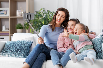 family, technology and people concept - happy mother and daughter with smartphone taking selfie at home