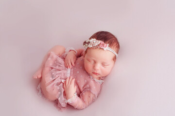 Lovely newborn girl sleeping on pink blanket  . Closeup portrait of a beautiful,  sleeping baby...