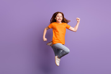 Full length body size view of attractive funny cheerful girl jumping running having fun isolated over violet purple color background