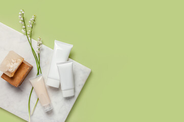 Flat lay composition with cosmetic products on green background. Copy space.