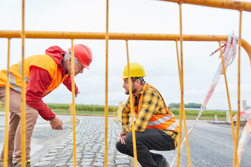 Bauarbeiter auf der Baustelle kontrollieren die Fahrbahn