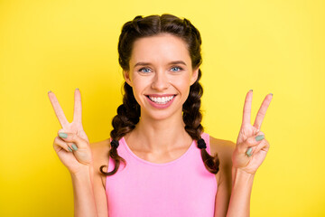 Photo of sweet charming young lady braids dressed singlet showing v-sign two hands arms isolated yellow color background