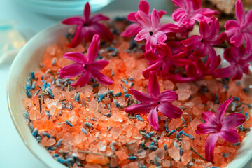 Organic medicinal sea salt with dried aromatic herbs and flowers on a ceramic plate close-up