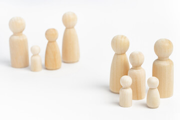 Family members made from wooden figurines on white background. Family with many children, multi-child or multi-member family. Isolation, social distancing between families