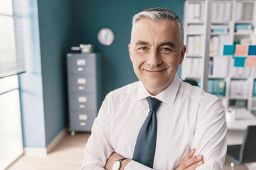 Fototapeta premium Confident smiling businessman posing in his office