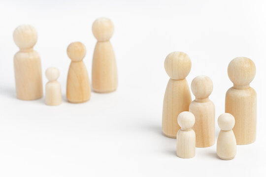 Family members made from wooden figurines on white background. Family with many children, multi-child or multi-member family. Isolation, social distancing between families - Powered by Adobe