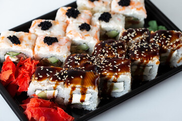 Rice square rolls with shrimp, eel, vegetables, creamy white cheese and sweet sauce. Asian sushi from the fast delivery service