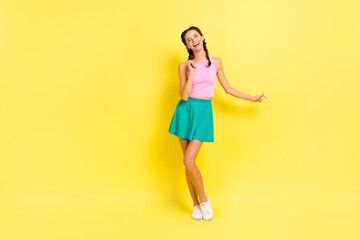 Fototapeta na wymiar Full size photo of optimistic nice brunette lady dance wear pink top blue skirt isolated on vivid yellow color background