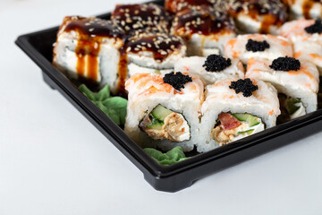 Rice square rolls with shrimp, eel, vegetables, creamy white cheese and sweet sauce. Asian sushi from the fast delivery service