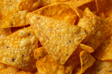 Crispy corn chips, triangular-shaped nachos with a cheese flavor. Fast food close-up - 429176996